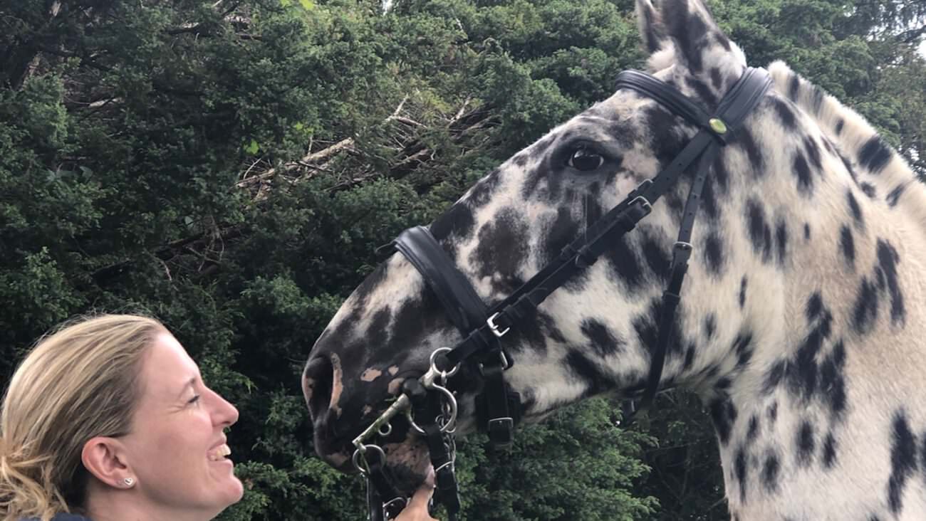 A lady with a appaloosa horse in hand