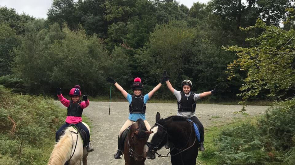 3 GIRLS RIDING WITH HANDS WIDE APART