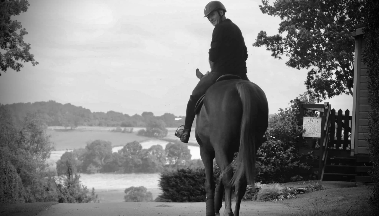 A mono photo of a rider in open countryside