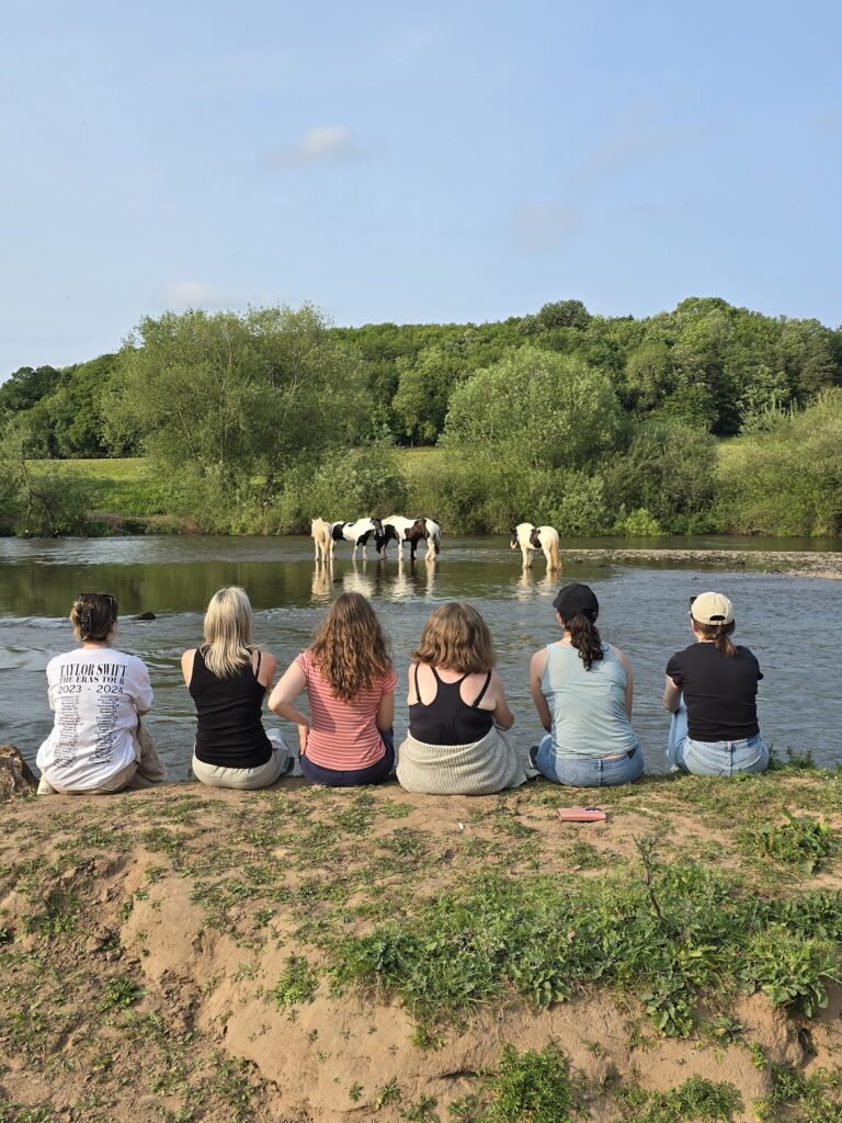 Ladies sat by the river severn watching the horses at bank farm equestrian